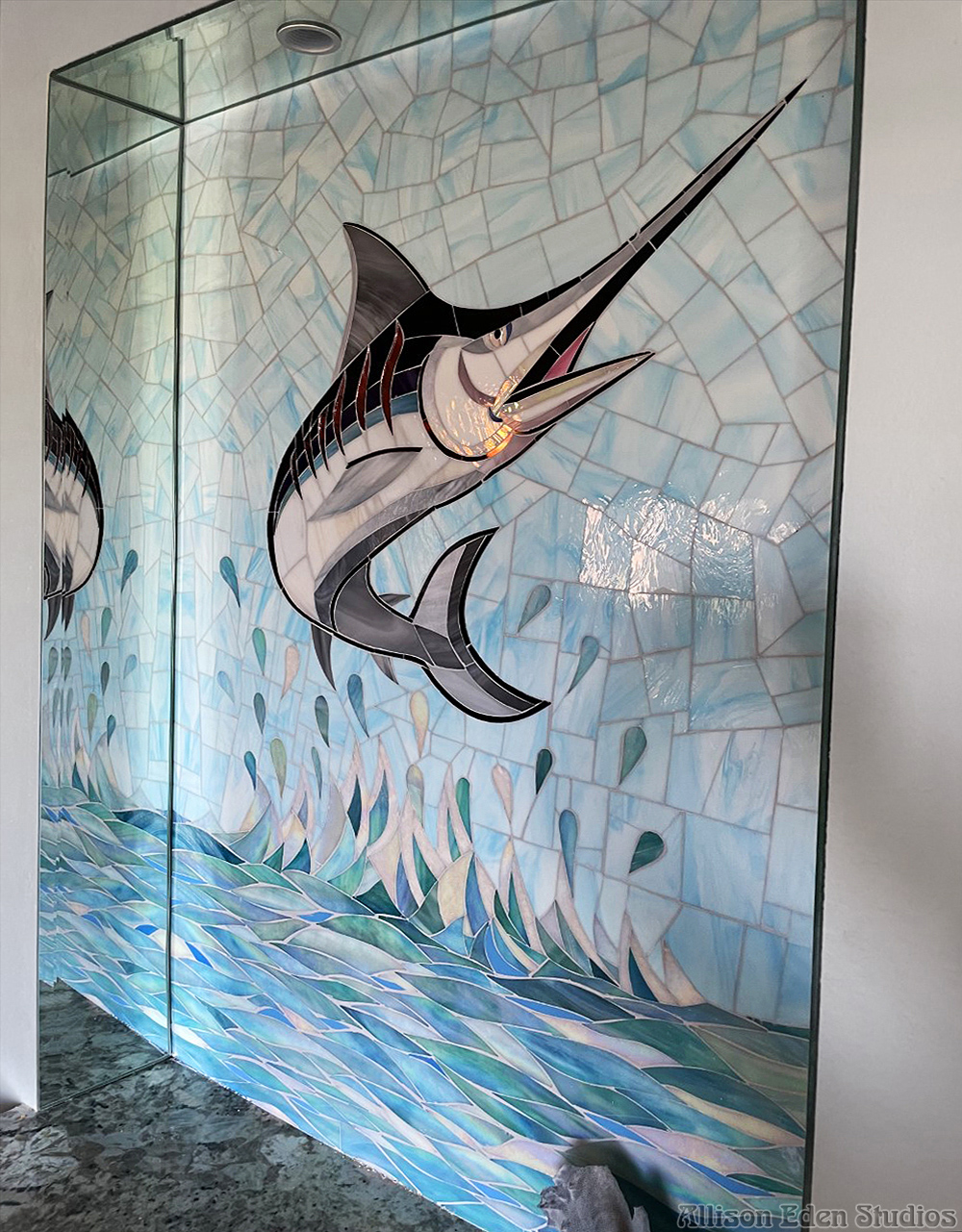 Hand-cut swordfish mosaic wall art with blue ocean waves and iridescent stained glass