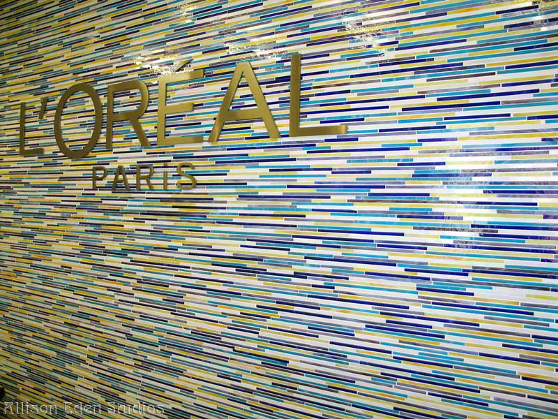 Custom blue stained glass mosaic feature wall created by Allison Eden Studios for the L'Oréal Paris New York headquarters reception area.