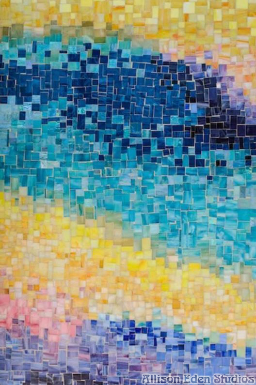 Close-up of handcrafted stained glass mosaic tiles showing soft Arizona sunset color gradations in a luxury resort spa installation.