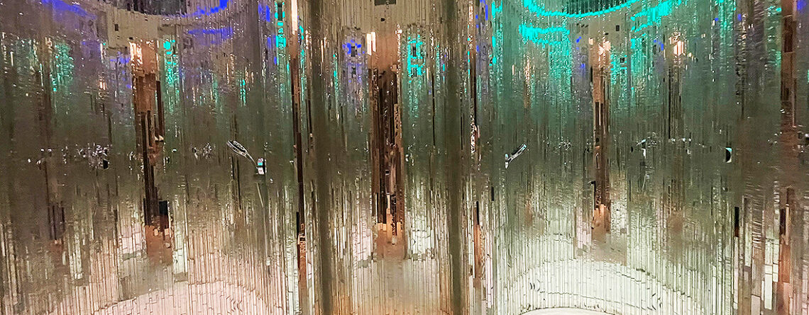 Custom handcrafted vertical mirror mosaic walls by Allison Eden Studios installed in a luxury spa in Nassau, Bahamas featuring curved architectural surfaces and shimmering reflective glass.
