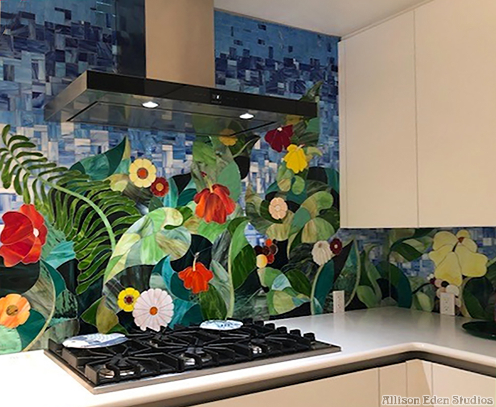 Custom tropical floral stained glass mosaic kitchen backsplash by Allison Eden Studios featuring hibiscus flowers, palm leaves and lush green foliage.