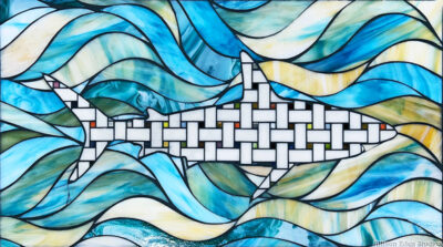 Handcrafted stained glass shark mosaic artwork by Allison Eden Studios featuring a geometric shark swimming through layered blue, turquoise and ivory ocean waves.