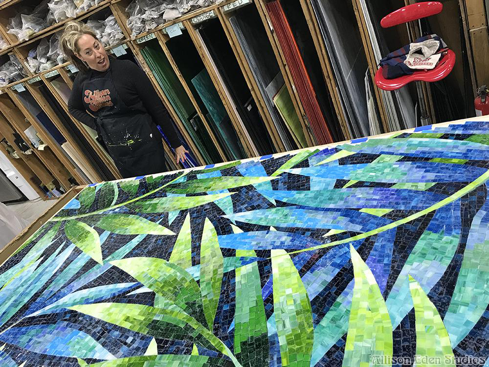 Allison Eden working on a handcrafted palm leaf stained glass mosaic in the Brooklyn studio.
