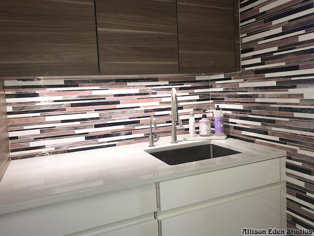 Modern custom Barcode glass mosaic kitchen backsplash by Allison Eden Studios featuring handcrafted linear stained glass tiles in plum, ivory, black, and gray installed in a contemporary luxury kitchen