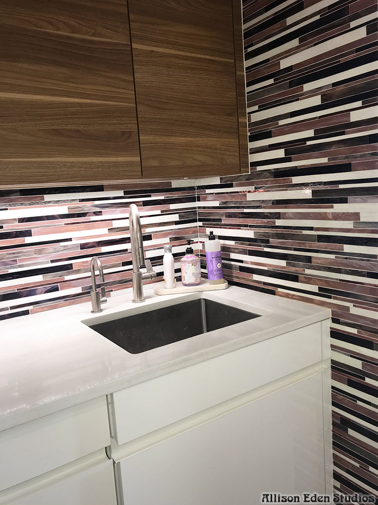 Modern custom Barcode glass mosaic kitchen backsplash by Allison Eden Studios featuring handcrafted linear stained glass tiles in plum, ivory, black, and gray installed in a contemporary luxury kitchen