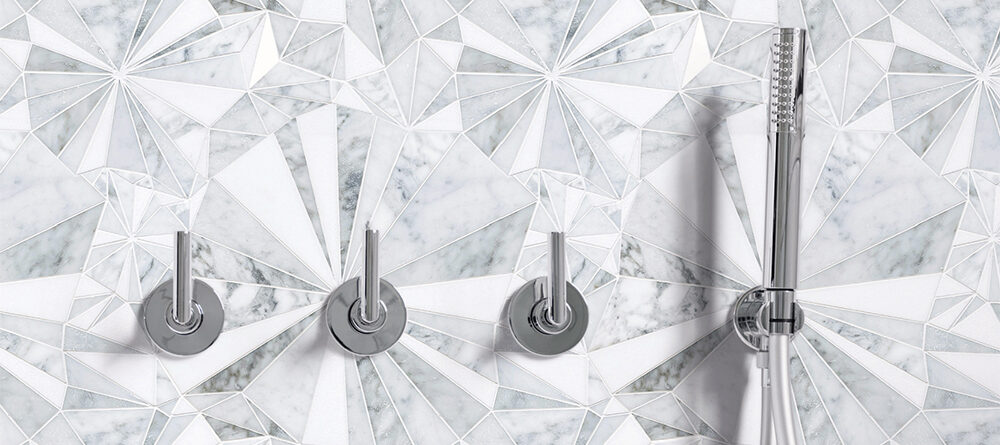 Luxury shower wall featuring Allison Eden Studios Starburst white and grey geometric marble mosaic with chrome fixtures