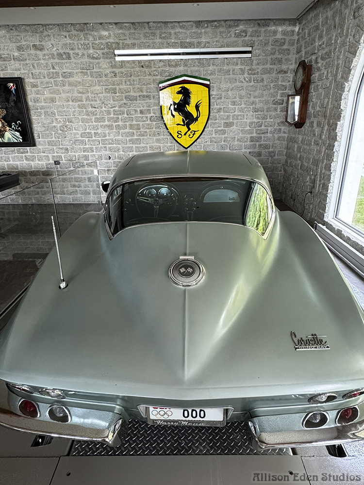 Custom Ferrari-inspired stained glass mosaic artwork by Allison Eden Studios displayed with a 1966 Corvette in a luxury car collection