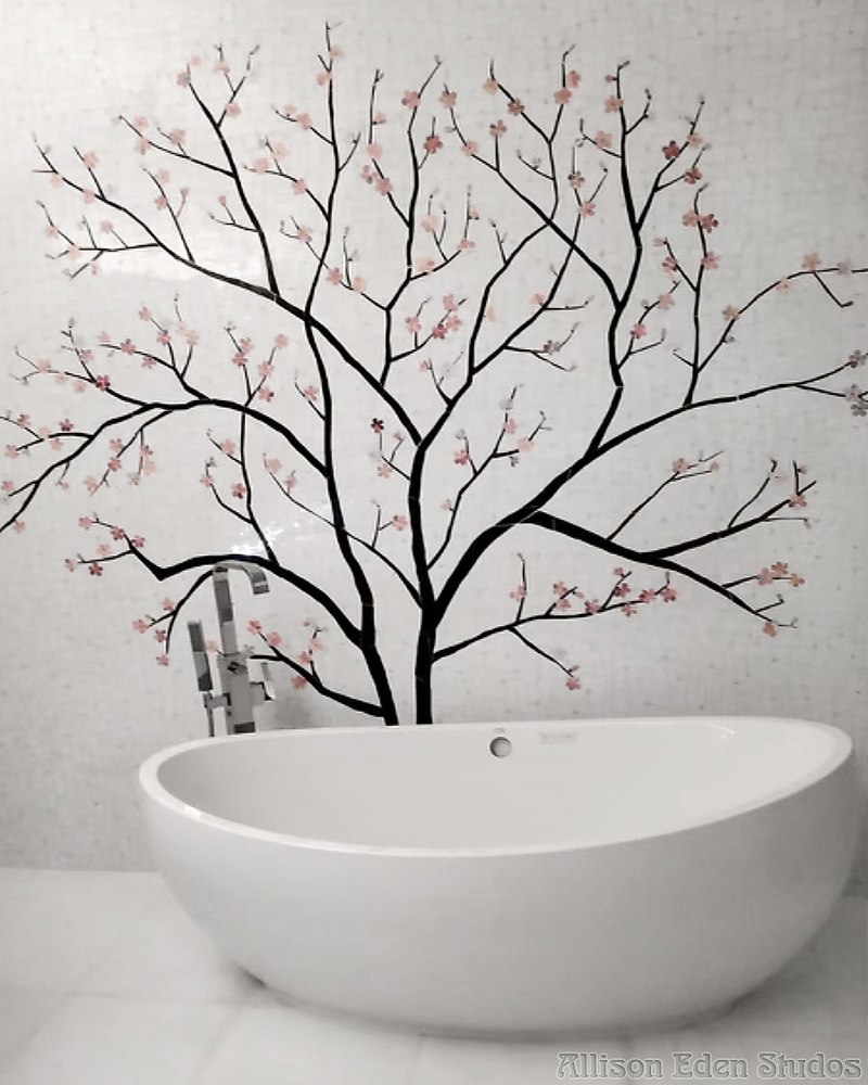 Custom cherry blossom stained glass mosaic mural behind a freestanding white bathtub by Allison Eden Studios
