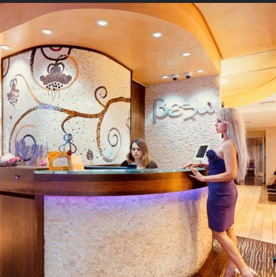 Custom floral glass mosaic mural by Allison Eden behind the curved reception desk at BeSu Salon & Day Spa in New York City.besu salon spa reception glass mosaic allison eden