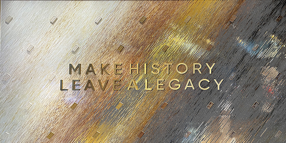 Close-up of Allison Eden's stained glass mosaic at Circa Las Vegas, featuring gold Make History Leave a Legacy lettering and a diagonal gradation of ivory, amber, and charcoal glass.