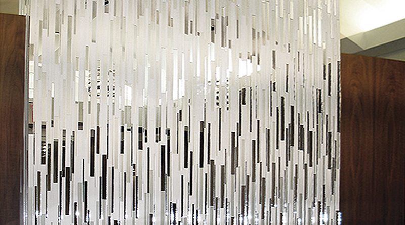 Custom mirror mosaic reception desk by Allison Eden Studios featuring individually cut vertical strips of reflective and brushed mirror glass in a contemporary New York City showroom.