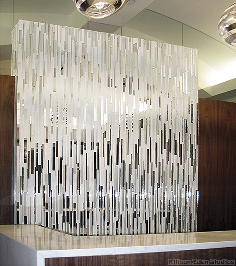 Custom mirror mosaic reception desk by Allison Eden Studios featuring individually cut vertical strips of reflective and brushed mirror glass in a contemporary New York City showroom.