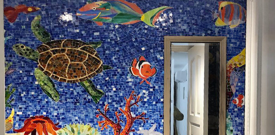 Close-up of a handcrafted stained glass sea turtle and tropical fish within a custom aquatic mosaic mural by Allison Eden Studios.